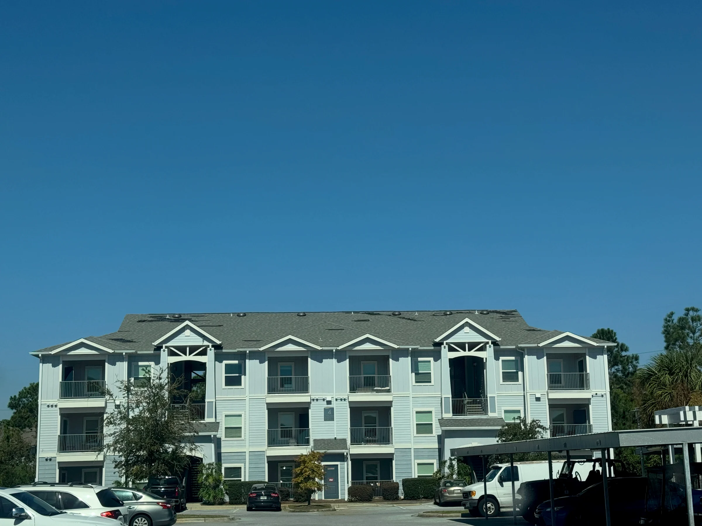 Visible missing shingles on a multifamily property roof